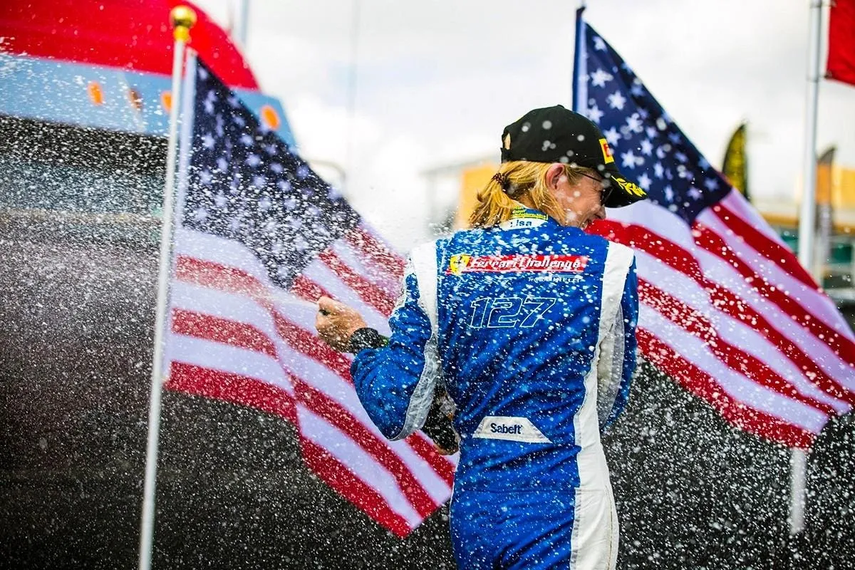Lisa Clark turns from the champagne shower on the podium